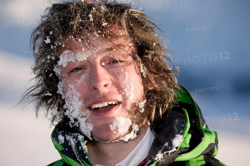 Young man with his face full of snow
