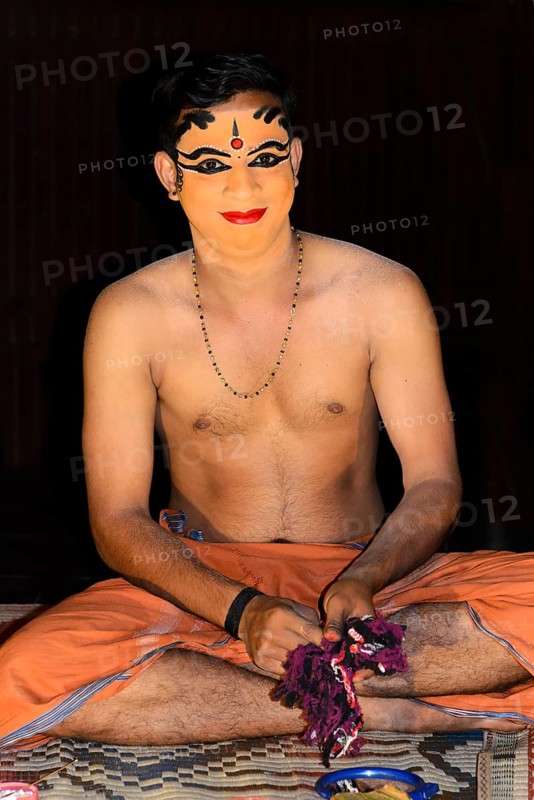 Kathakali dancer applying makeup in preparation for his performance