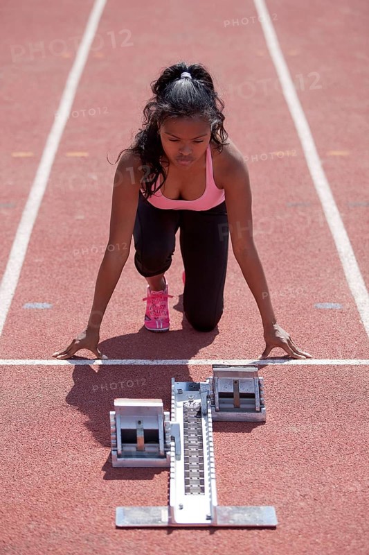 Sporty young woman getting ready on running track
