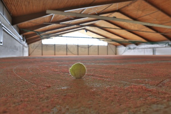 Damaged tennis ball standing in a tennis hall in need of redevelopment