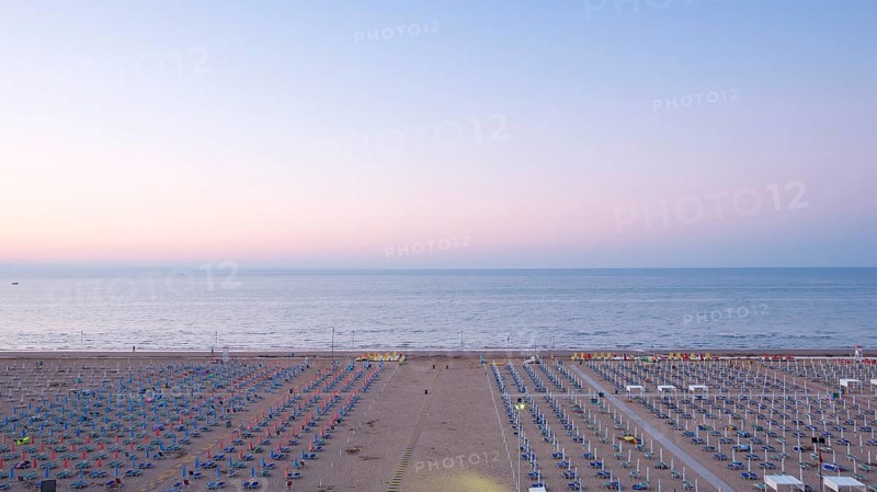 View of a beach with sunshades and sun beds