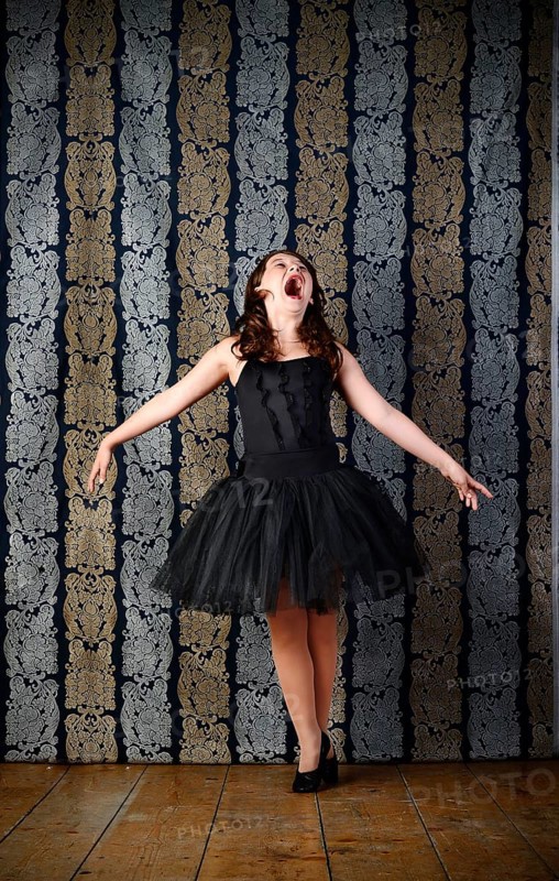 Girl wearing a black ballet dress screaming