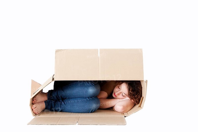 Young woman sleeping in a removal box