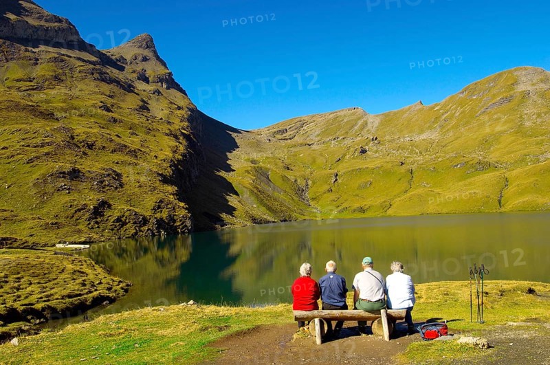 Walkers having a rest next to Bachalpsee lake near Grindelwald First