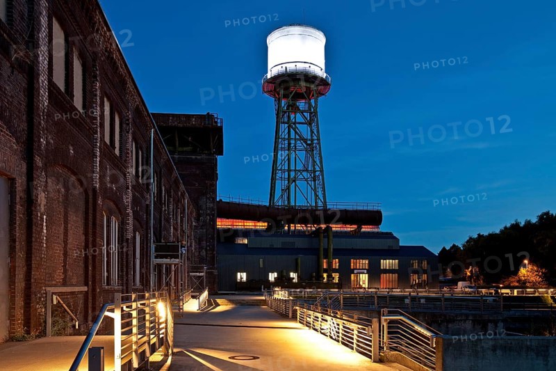 Jahrhunderthalle or Centennial Hall with a water tower at dusk