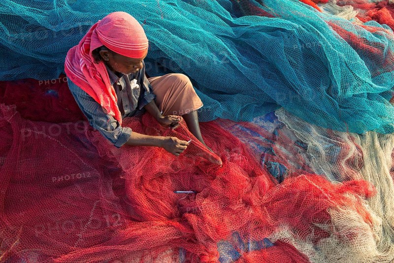 Fisherman repairing fishing nets