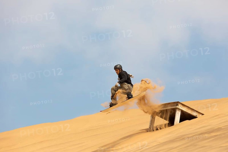Sand boarding in the dunes of the Namib Desert