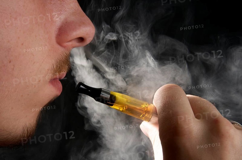 Man smoking an electronic cigarette and exhaling vapour