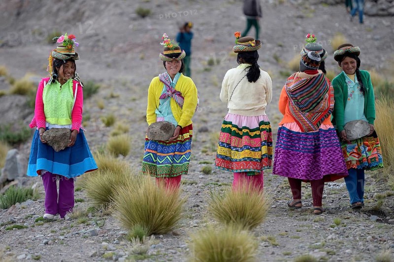 Young women carrying heavy stones to secure the shores of an artificial lake for irrigation