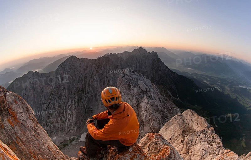 Climber sitting on the top of Ellmauer Halt at sunrise