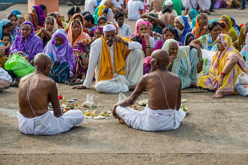 Two men and a pandit or priest are performing Dashkriya or Asthi Visarjan