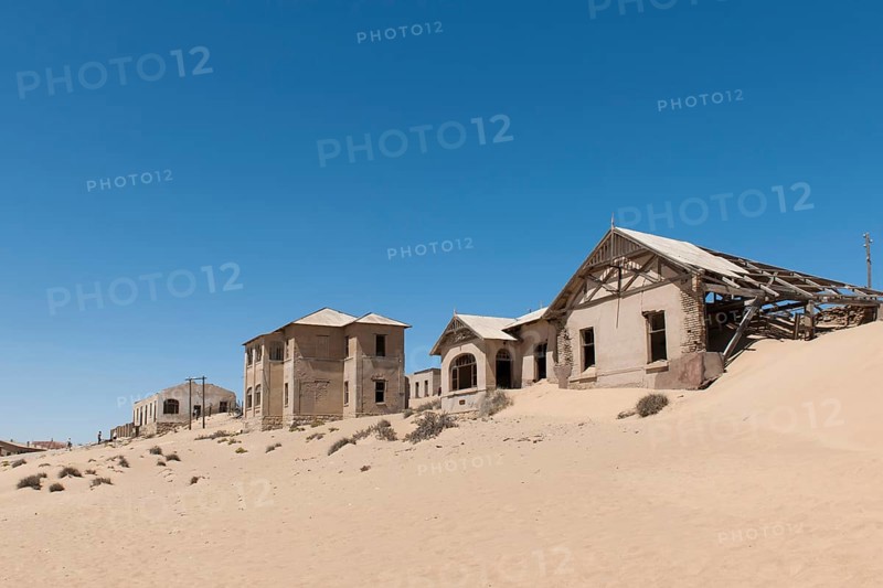Houses of a former diamond miners settlement that is slowly covered by the sand of the Namib Desert