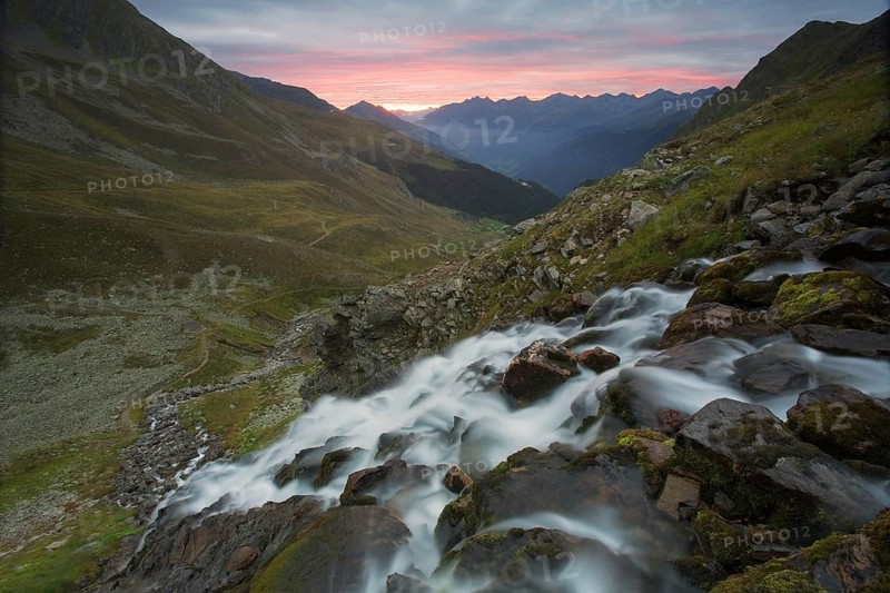 A mountain stream waterfall at sunrise