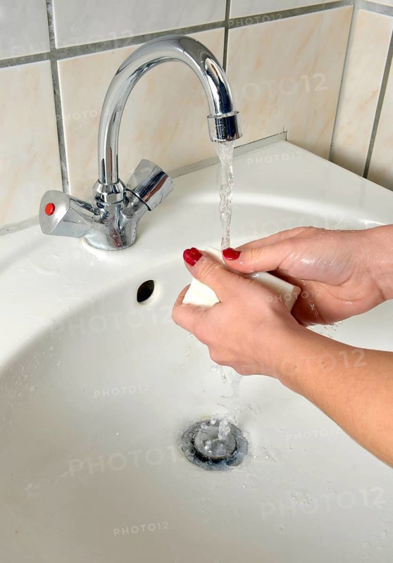 Washing hands with German curd soap in a washbasin