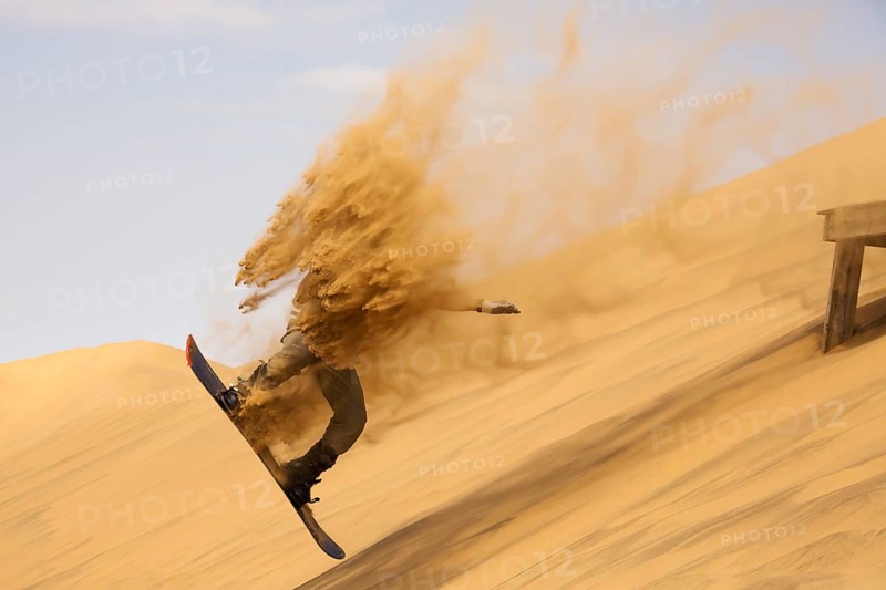 Sand boarding in the dunes of the Namib Desert