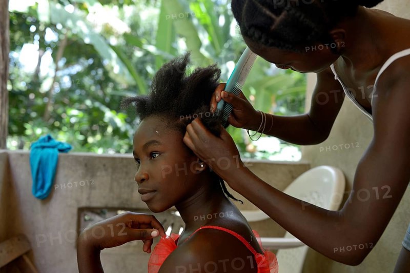 Young women braiding their hair