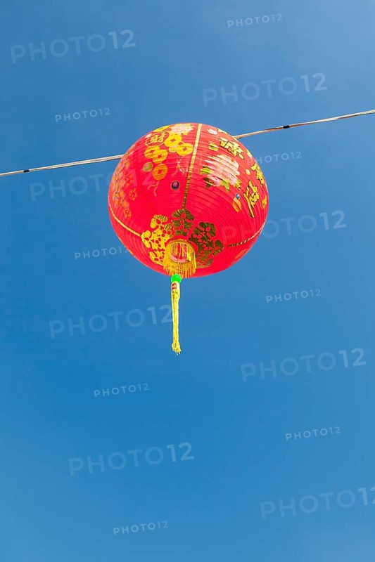 Red Chinese New Year lantern against blue sky
