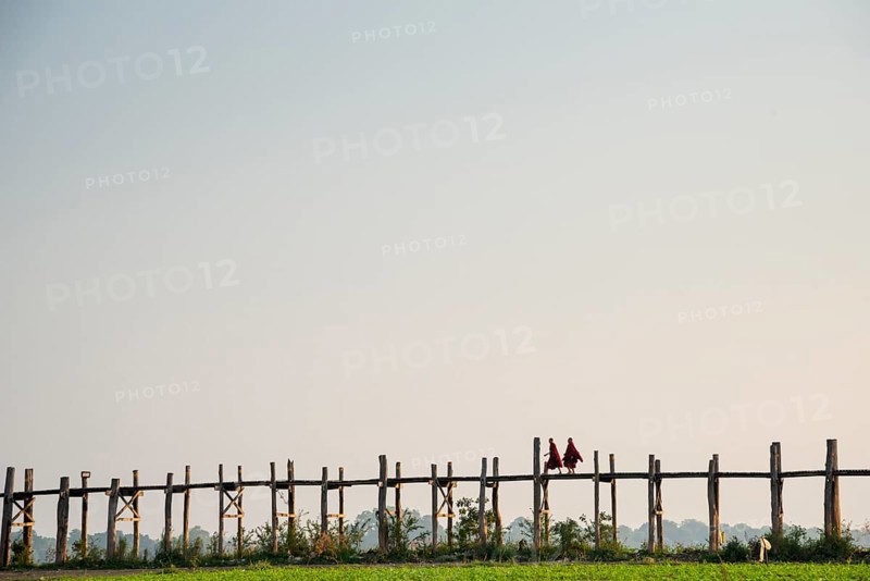 Monks walking on a teak bridge