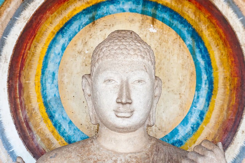 Head of a Buddha figure surrounded by a nimbus in rainbow colors