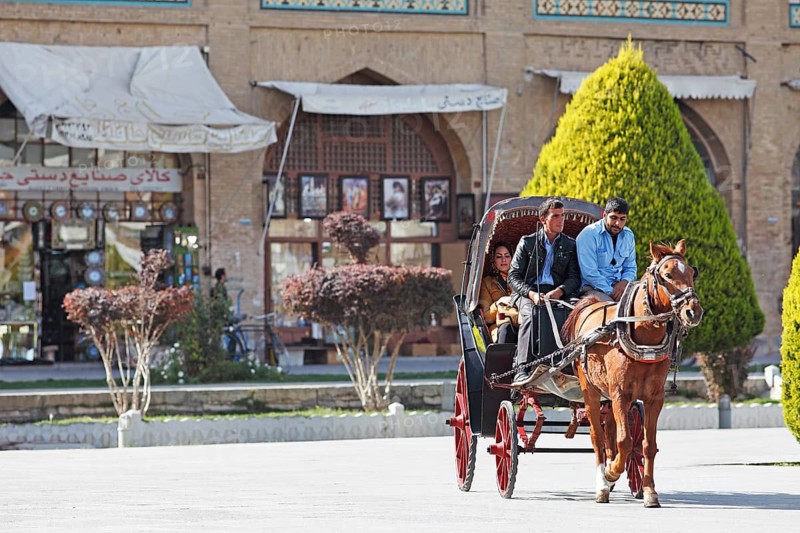Iranians riding in a horse-drawn carriage