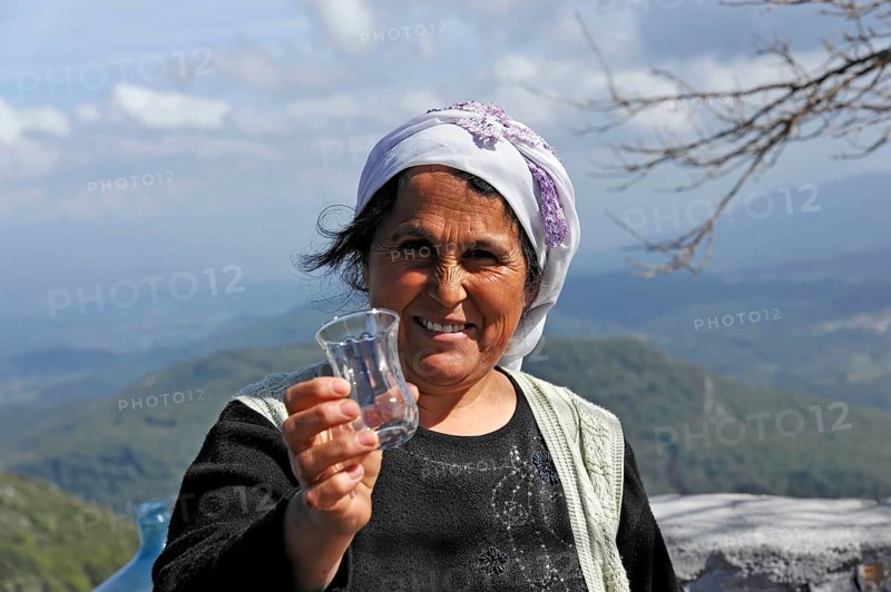 Turkish woman passing a glass in Akyaka