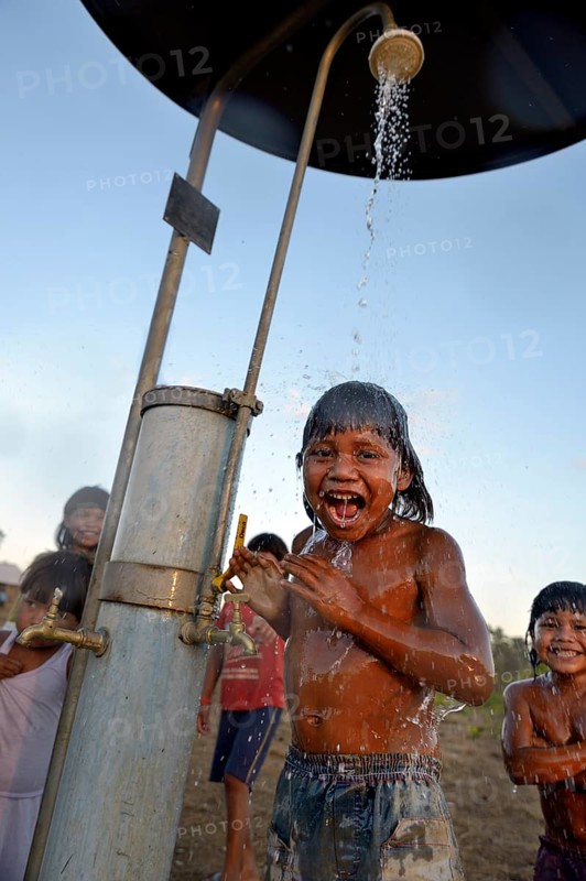 Boy of the Xavantes people taking a shower at a waterhole