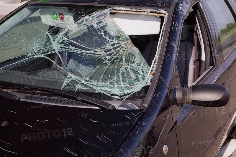 Black compact car with an accident-damaged windshield