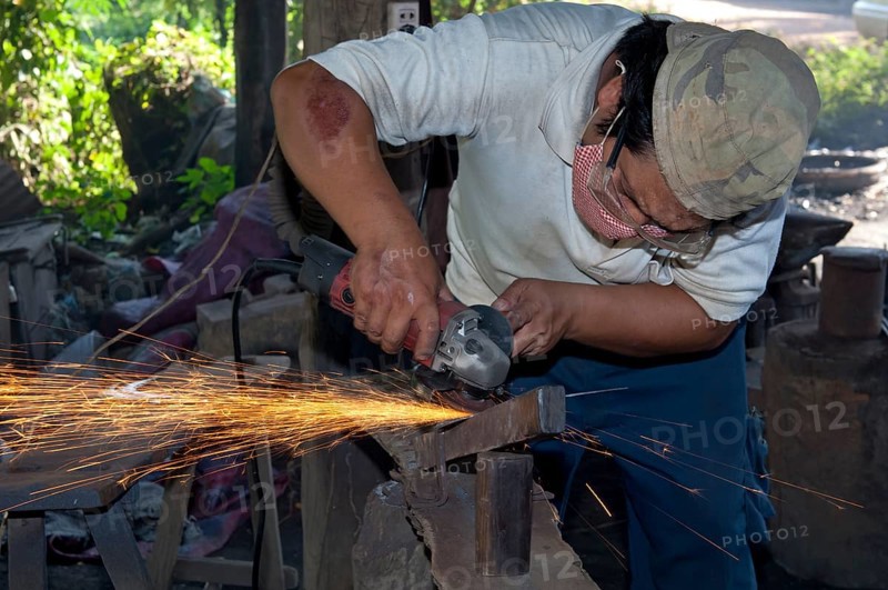 Metal worker grinding in a metalworking shop