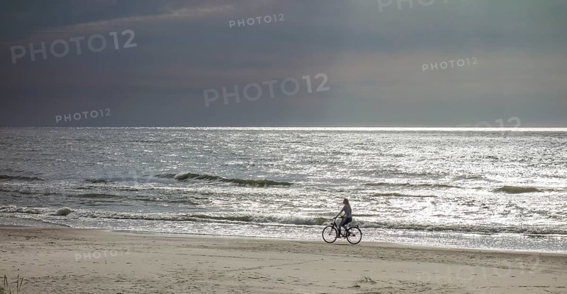 Cyclist on the sandy beach on the Baltic Sea
