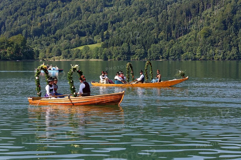 Locals wearing traditional costumes in decorated wooden Platte boats