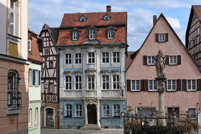 Schoner Brunnen fountain with a Rococo building at back