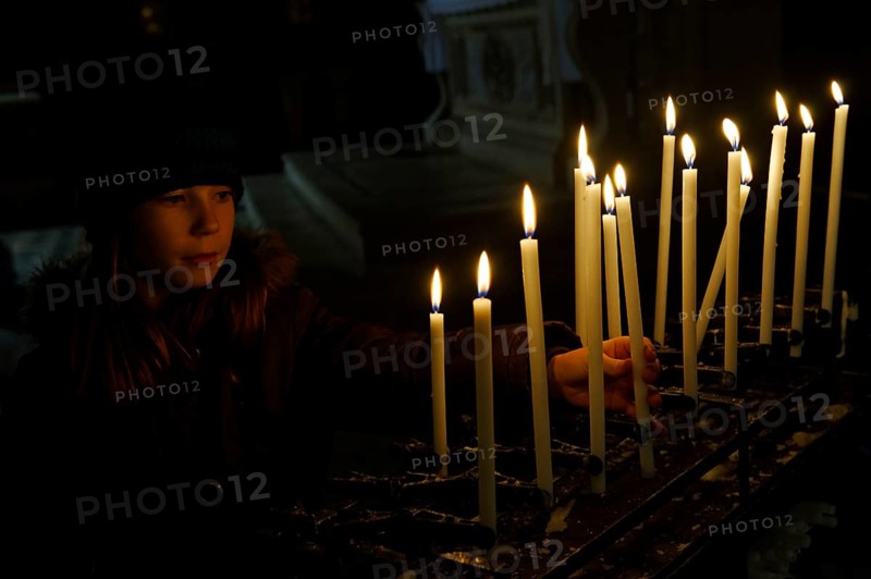 Girl lighting a votive candle