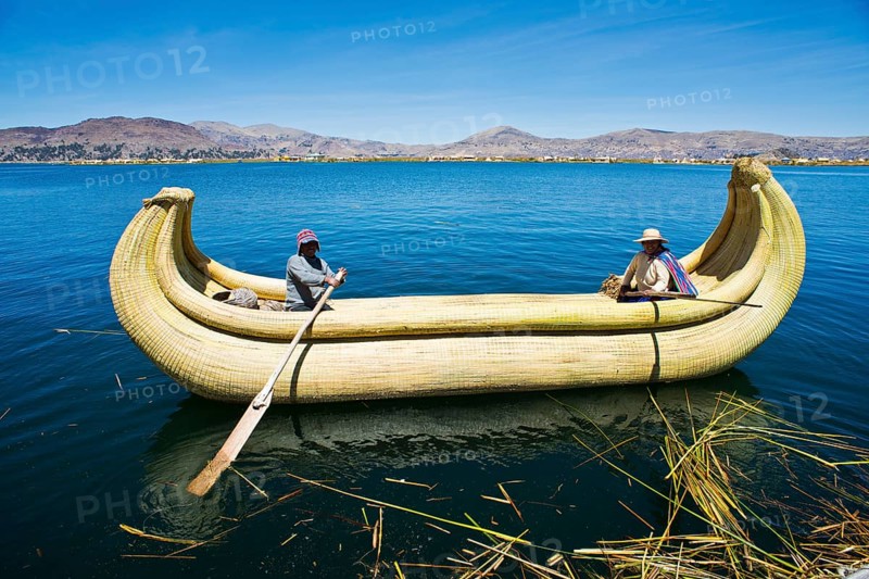 Two local in a traditional rowing boat of Totora reed on Lake Titicaca