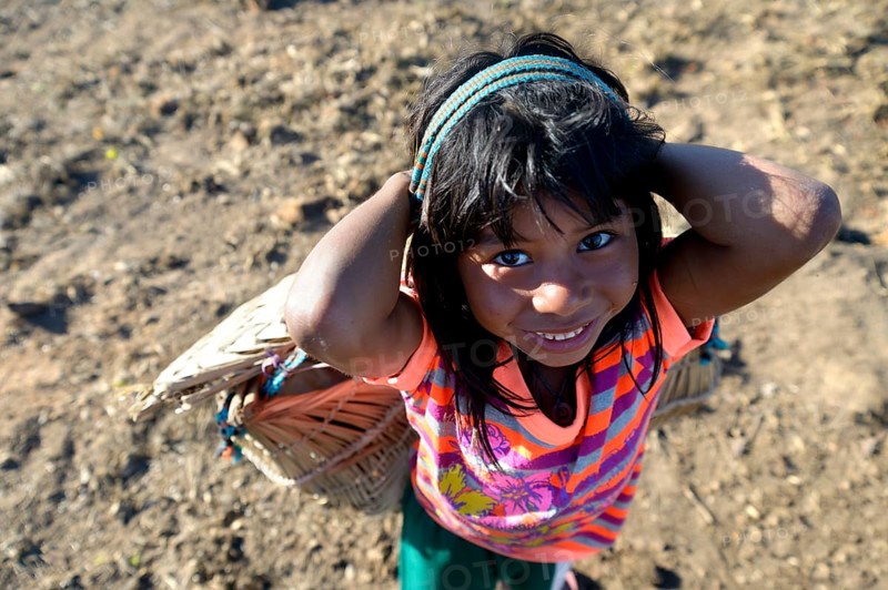 Girl carrying a traditional basket on her back in a village of the Xavantes people