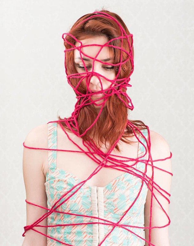 Woman constrained with pink cotton yarn