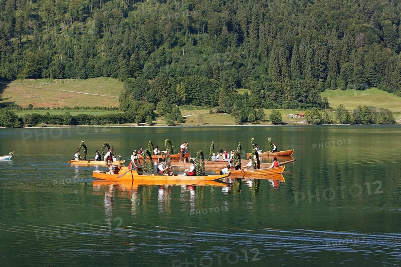 Locals wearing traditional costumes in decorated wooden Platte boats