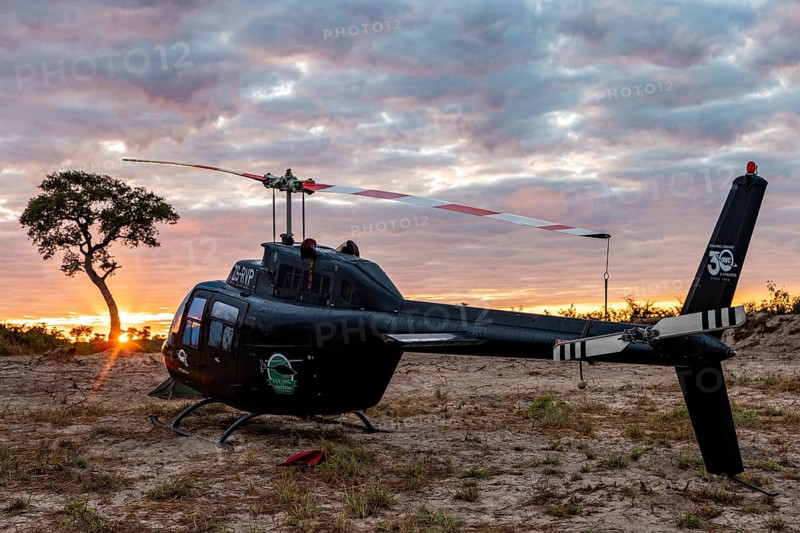 Helicopter in the African savannah at sunset