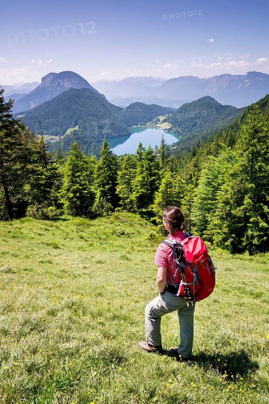Female hiker observing the view from the Wilder-Kaiser-Steig hiking trail towards Hintersteiner Lake