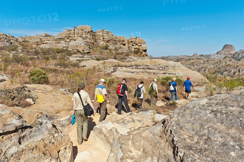 Hikers on trail through rocky landscape