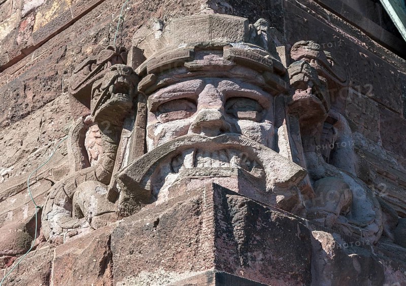 Snarling sandstone head mask and snakes