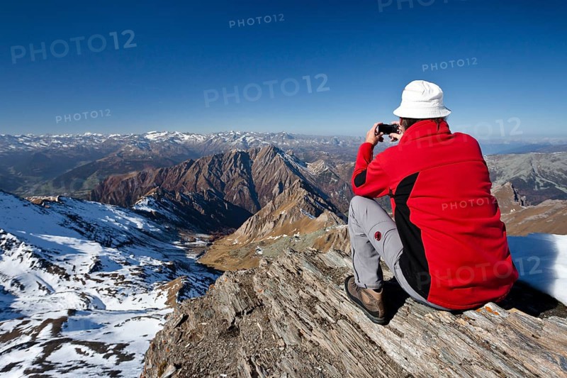 Mountain climber on the summit of Wilde Kreuzspitze Mountain with views over the Pfunderer Mountains towards the Wipptal valley