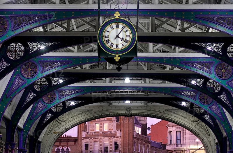 Clock and wrought iron ornaments at dusk