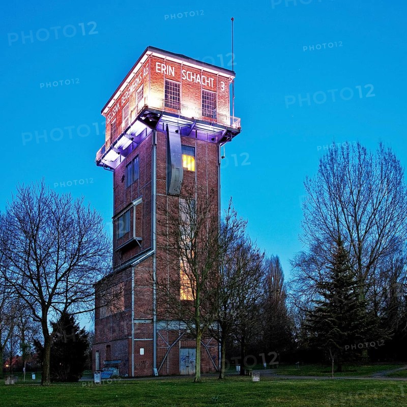 The illuminated Hammerkopfturm tower of Zeche Erin Colliery at dusk