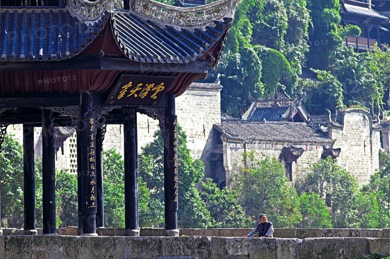 Old woman standing next to the Kuixingge Pagoda