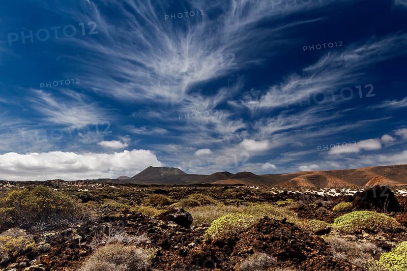 Cirrus clouds over volcanic landscape