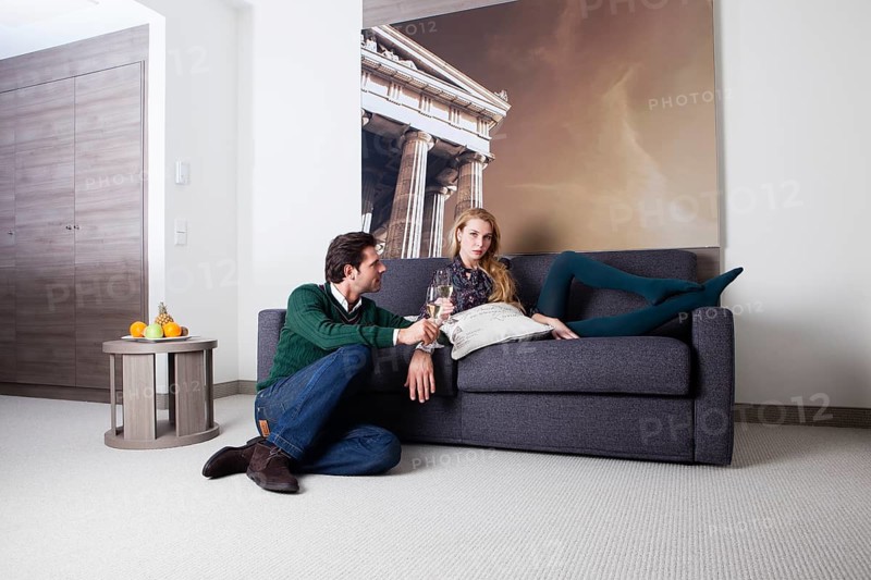 Man and woman on a couch in a hotel room