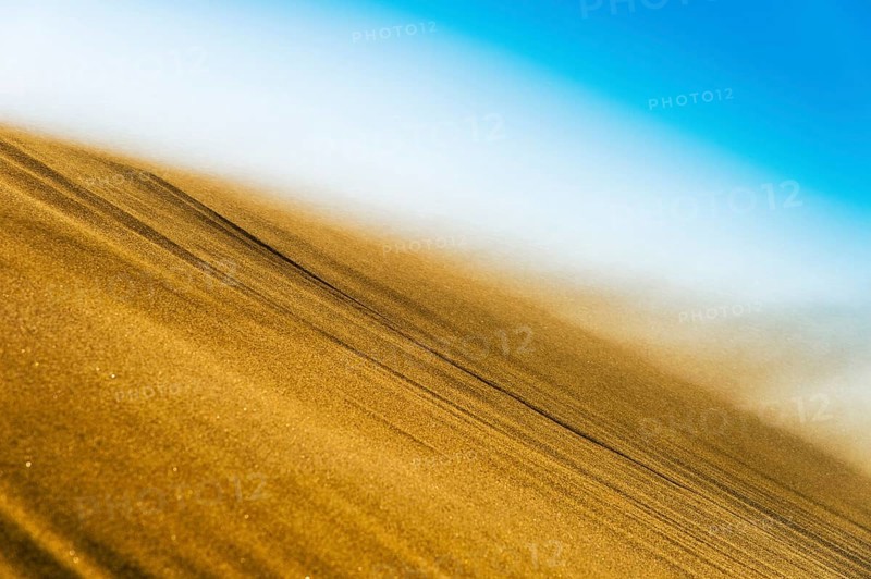 Sand blowing in a storm over the crest of a dune
