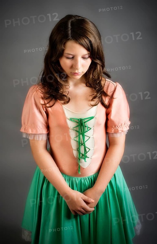 Girl wearing an old-fashioned dress looking sad