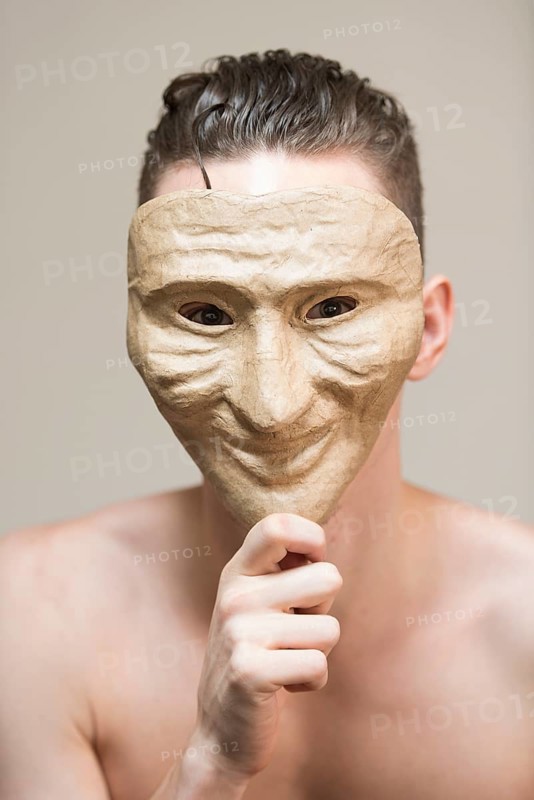 Man hiding behind a happy mask