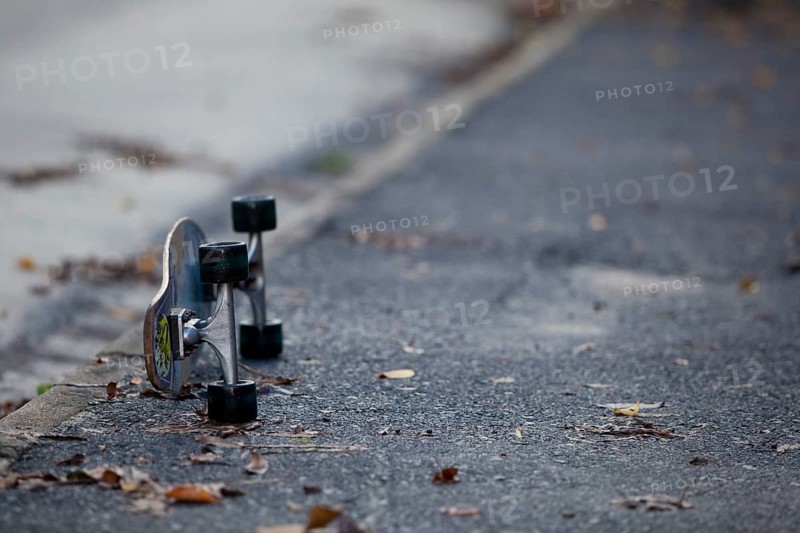 Skateboard lying on a wet street